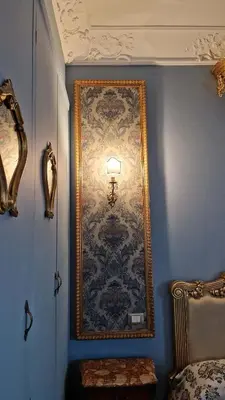 a wall with a large painting on a blue wall at La Baronessa in Palermo