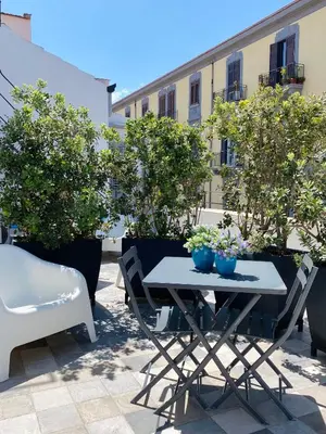 a table and chairs on a patio with trees at Attico Belvedere in Palermo