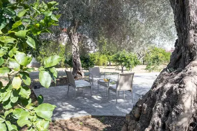a table and chairs sitting under a tree at Nice home in Carini