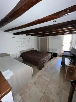 a bedroom with two beds and a wall with writing on the wall at House del Corso in Palermo