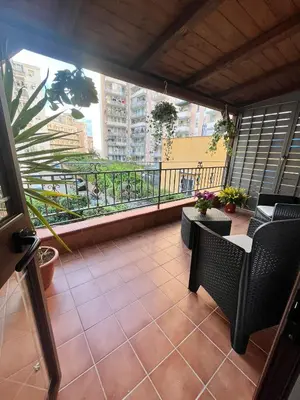 a balcony with chairs and a view of a city at House del Corso in Palermo
