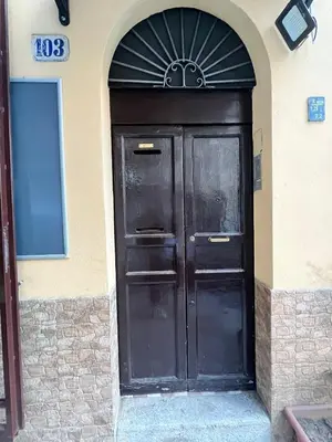 a large black door on the side of a building at House del Corso in Palermo