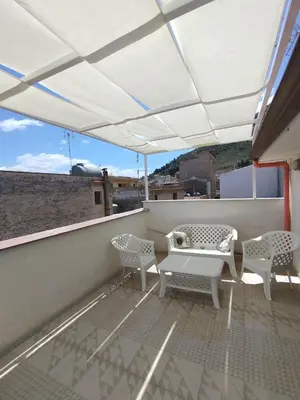 a patio with a table and chairs on a roof at AFFITTACAMERE LE SIGNORINE in Castellammare del Golfo