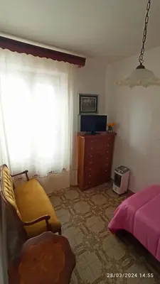 a bedroom with a bed and a chair and a window at AFFITTACAMERE LE SIGNORINE in Castellammare del Golfo