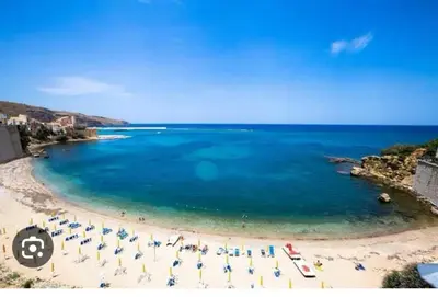 a beach with a bunch of umbrellas and people on it at AFFITTACAMERE LE SIGNORINE in Castellammare del Golfo