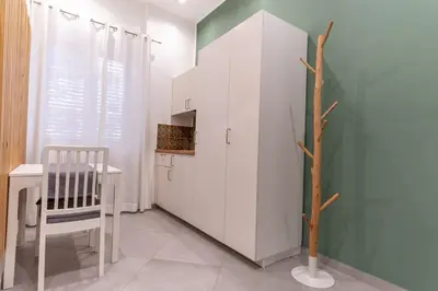 a kitchen with a table and a white refrigerator at Nena Sweet Home in Palermo
