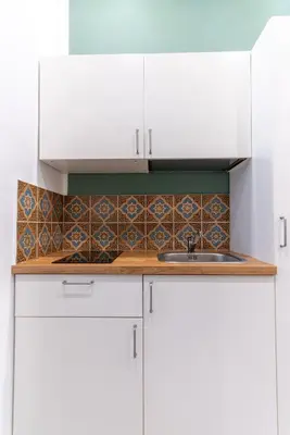 a kitchen with white cabinets and a sink at Nena Sweet Home in Palermo