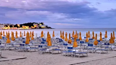 a bunch of chairs and umbrellas on a beach at mansarda beach Mondello in Palermo