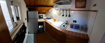 a kitchen with a refrigerator and a counter top at mansarda beach Mondello in Palermo