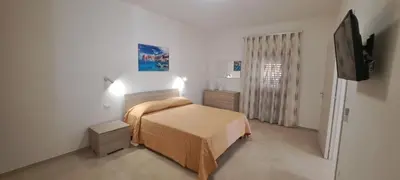 a bedroom with a bed and a flat screen tv at Mamma Rosa Casa Vacanze in Castellammare del Golfo