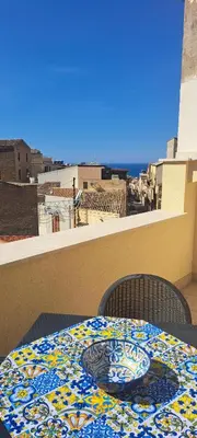 a table with a plate on top of a balcony at Mamma Rosa Casa Vacanze in Castellammare del Golfo