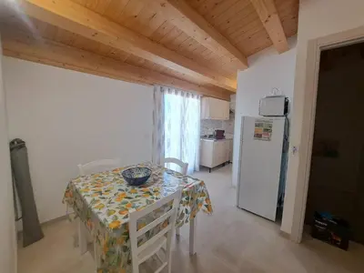 a dining room with a table and a refrigerator at Mamma Rosa Casa Vacanze in Castellammare del Golfo