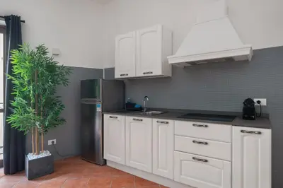 a kitchen with white cabinets and a stainless steel refrigerator at Suk Ballarò House in Palermo