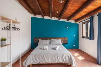 a bed in a room with a blue wall at Suk Ballarò House in Palermo