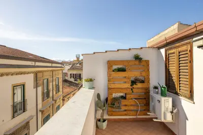 a balcony with a wooden door on a building at Suk Ballarò House in Palermo