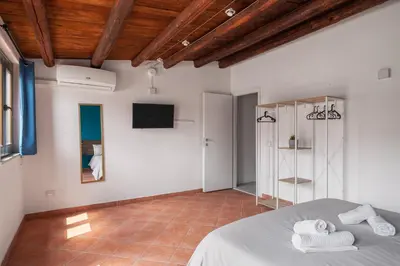 a bedroom with white walls and a bed with towels at Suk Ballarò House in Palermo