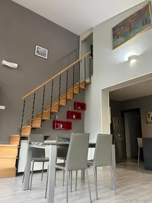 a dining room with a table and chairs and a staircase at Via delle Rose in Torretta