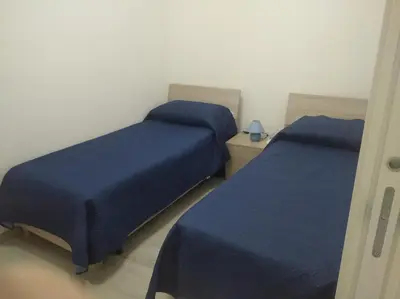 two beds in a room with blue sheets at Casa vacanze Venere in Balestrate