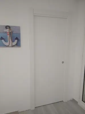 a white room with a door and a painting at Casa vacanze Venere in Balestrate
