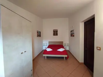 a bedroom with a red bed in a room at Trinity Apartments in Castellammare del Golfo