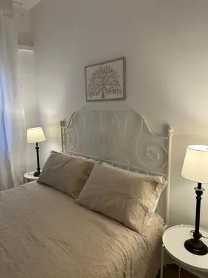a bed in a bedroom with two tables and two lamps at La Kalsa di Somavi in Palermo