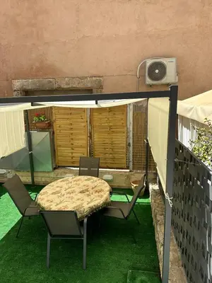 a small patio with a table and chairs on the grass at La Kalsa di Somavi in Palermo