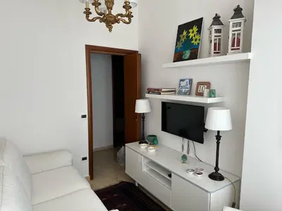 a living room with a tv and a white couch at La Kalsa di Somavi in Palermo