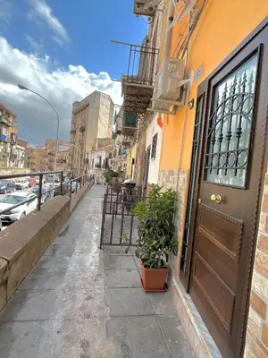 a street with a door and plants on the sidewalk at 'A Sicula in Palermo
