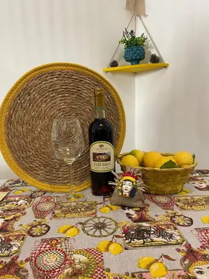 a bottle of wine and a basket of lemons on a table at 'A Sicula in Palermo