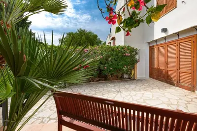 a wooden bench in a garden with plants and flowers at Casa ChiaraMarina in Macari
