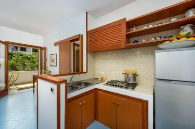 a kitchen with wooden cabinets and a white refrigerator at Casa ChiaraMarina in Macari