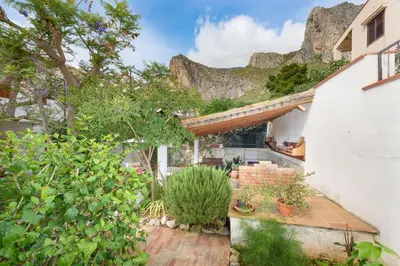 a house with a mountain in the background at Casa ChiaraMarina in Macari