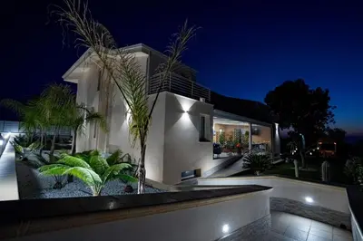 a house with a night view of it at B&B Alba in Terrasini