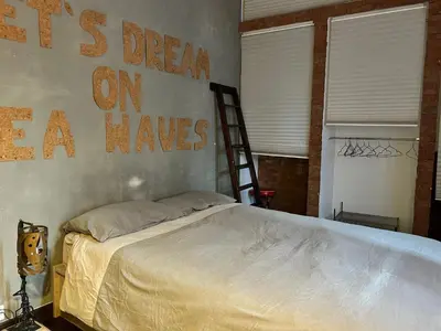 a bedroom with a bed with a sign on the wall at Casa Design con terrazzo in centro storico a Palermo in Palermo