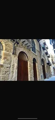 a brick building with a wooden door and windows at Casa Design con terrazzo in centro storico a Palermo in Palermo