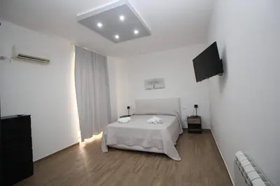 a white room with a bed and a television at La chiave dei sogni in Palermo