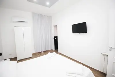 a living room with white walls and a tv at La chiave dei sogni in Palermo