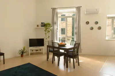 a dining room with a table and chairs and a television at La Casa del Mercado in Palermo
