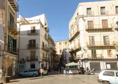 a group of buildings in a street with cars at La Casa del Mercado in Palermo