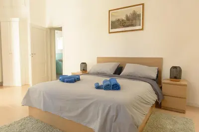 a bedroom with a bed with blue slippers on it at La Casa del Mercado in Palermo