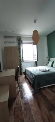 a bedroom with a bed and a desk and a window at Green Suite Palermo in Palermo