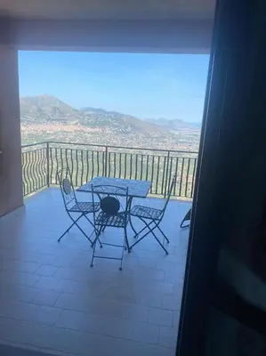 a table and chairs on a balcony with a view at IL PANORAMA in Altofonte
