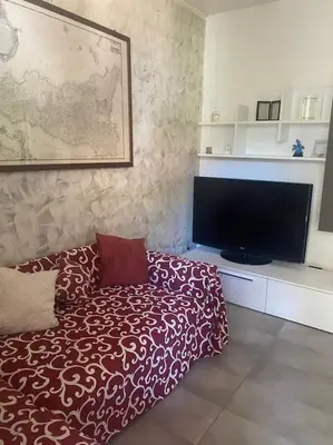 a living room with a bed and a flat screen tv at IL PANORAMA in Altofonte