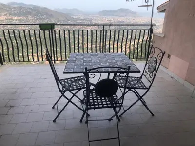 a table and two chairs on a balcony with a view at IL PANORAMA in Altofonte