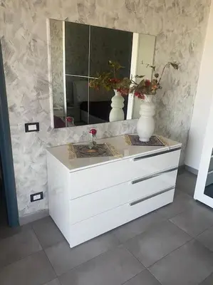 a white dresser with a mirror and two vases on it at IL PANORAMA in Altofonte