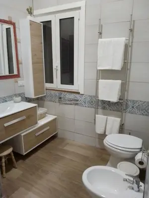 a bathroom with a toilet and a sink and a mirror at Casuzza Bedda e Duci in Mondello