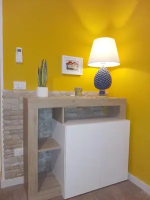 a desk with a lamp on a yellow wall at Casuzza Bedda e Duci in Mondello