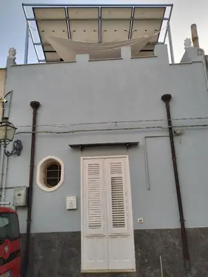 a white building with a door and a window at Dammuso SoleLuna. in Terrasini
