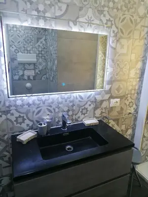 a bathroom with a black sink and a large mirror at Medea rooms palermo centro in Palermo