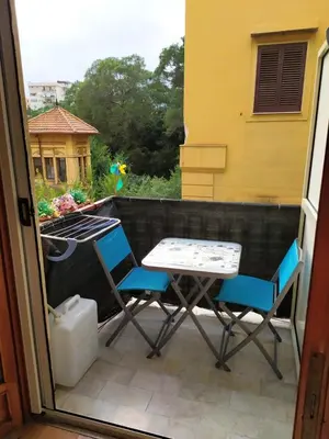 a patio with two chairs and a table on a balcony at Medea rooms palermo centro in Palermo